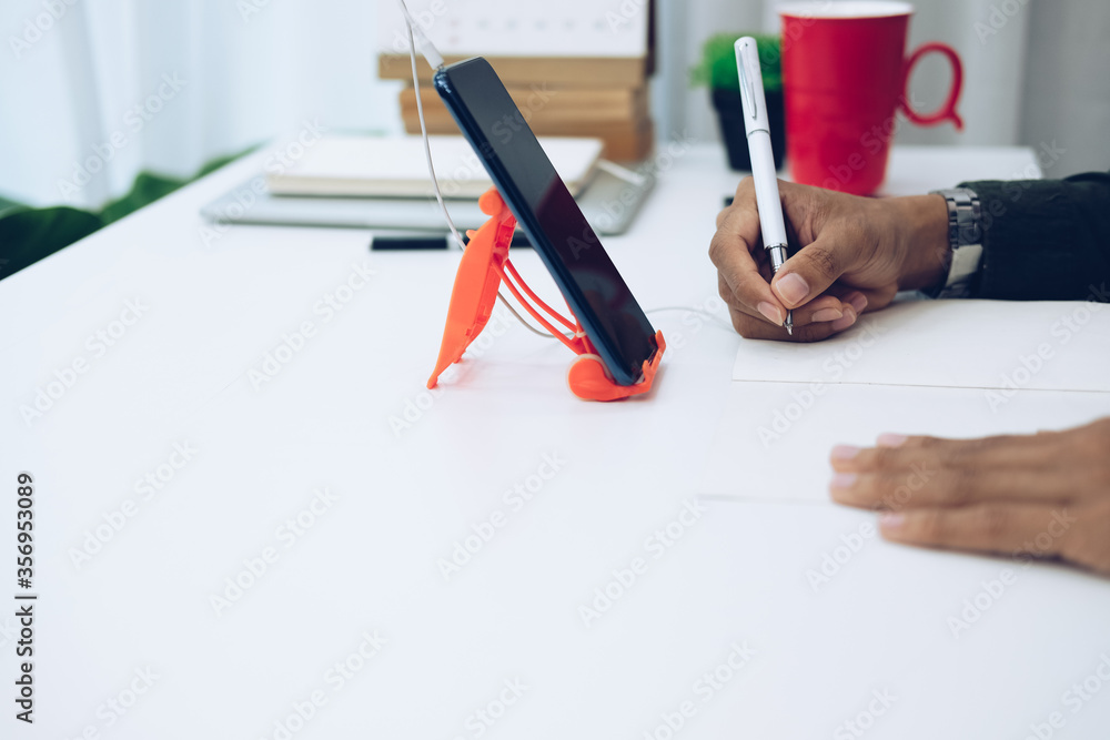 man wearing earphones writing note watching video. student listen lecture study online course man wearing earphones writing note watching video. student listen lecture study online course