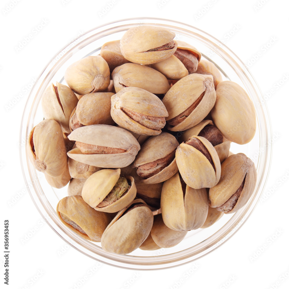Pistachio nuts in glass bowl isolated on white background flat lay closeup view Pistachio nuts in glass bowl isolated on white background flat lay closeup view