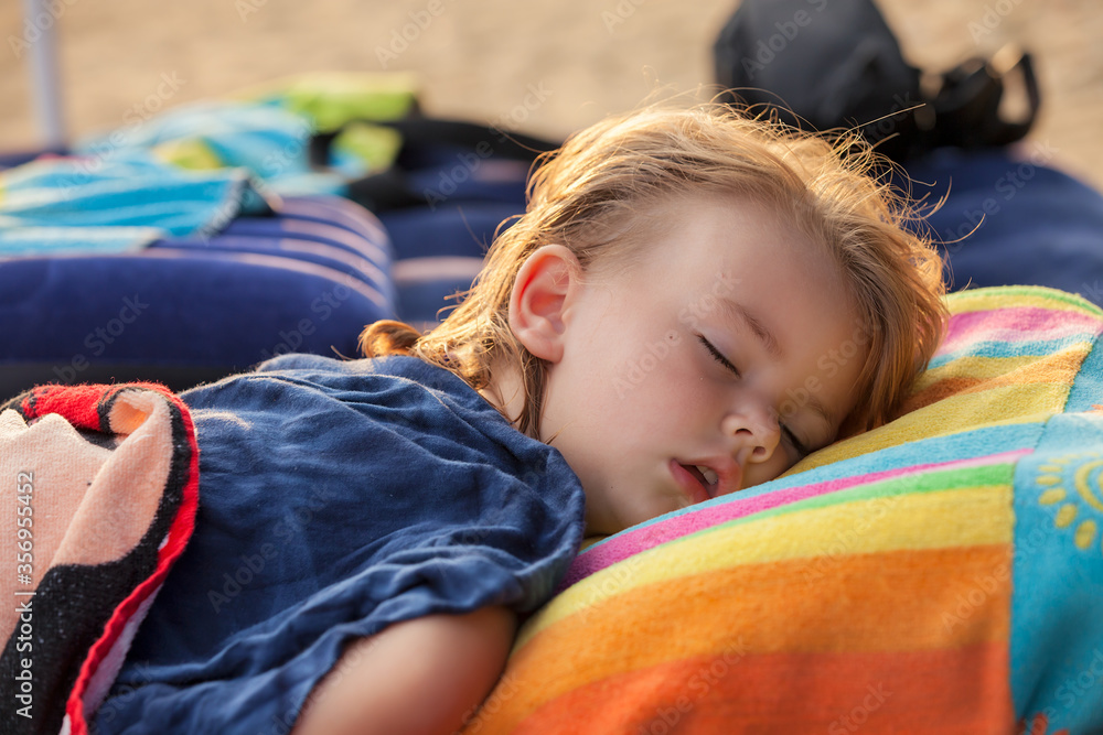 a little girl sleep on the beach