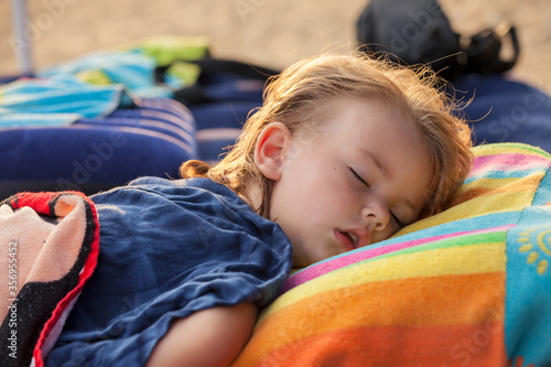 Obraz na płótnie a little girl sleep on the beach w salonie