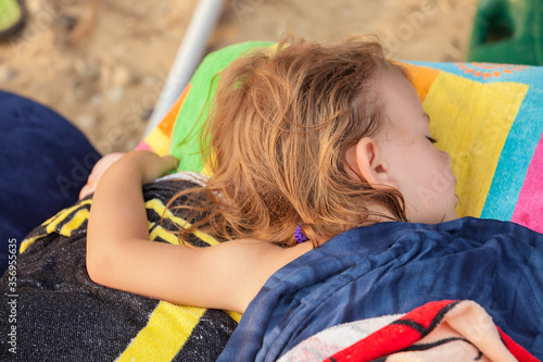a little girl sleep on the beach