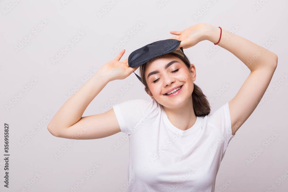 Smiling young woman with sleep mask isolated on white background Healthy sleep concept. Smiling young woman with sleep mask isolated on white background Healthy sleep concept.