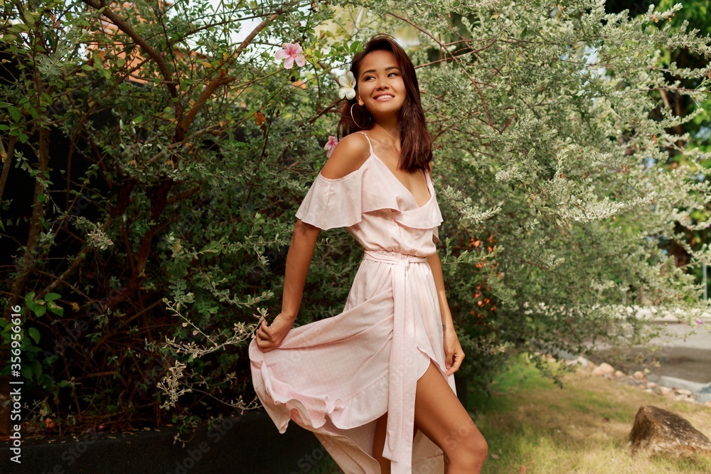 Outdoor summer fashion image of gorgeous Asian woman in stylish dress posing in the park. Outdoor summer fashion image of gorgeous Asian woman in stylish dress posing in the park.