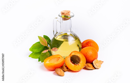 isolate, apricots with pits and a bottle with oil on a white background