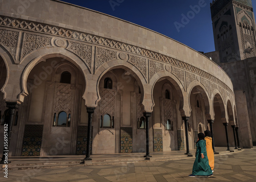 Zwei muslimische Frauen mit Hijab gehen zu den Arkaden der Hassan II Moschee in Casablanca Marokko