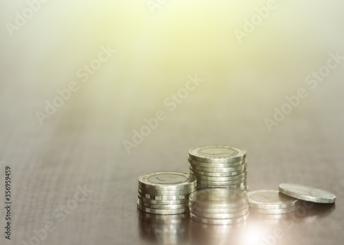 The close-up rows of money coins on desk with a blurred background