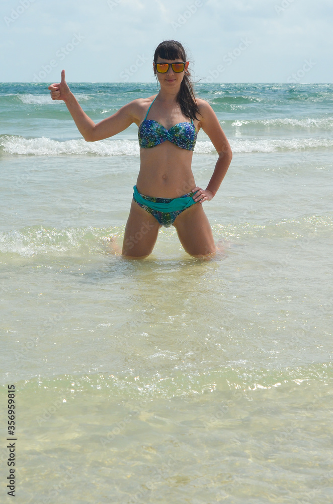 Young millennial girl in a swimsuit is having fun and enjoying life on vacation at the sea Young millennial girl in a swimsuit is having fun and enjoying life on vacation at the sea
