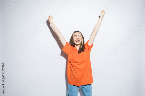 Portrait of a happy young woman with her hands up over white background