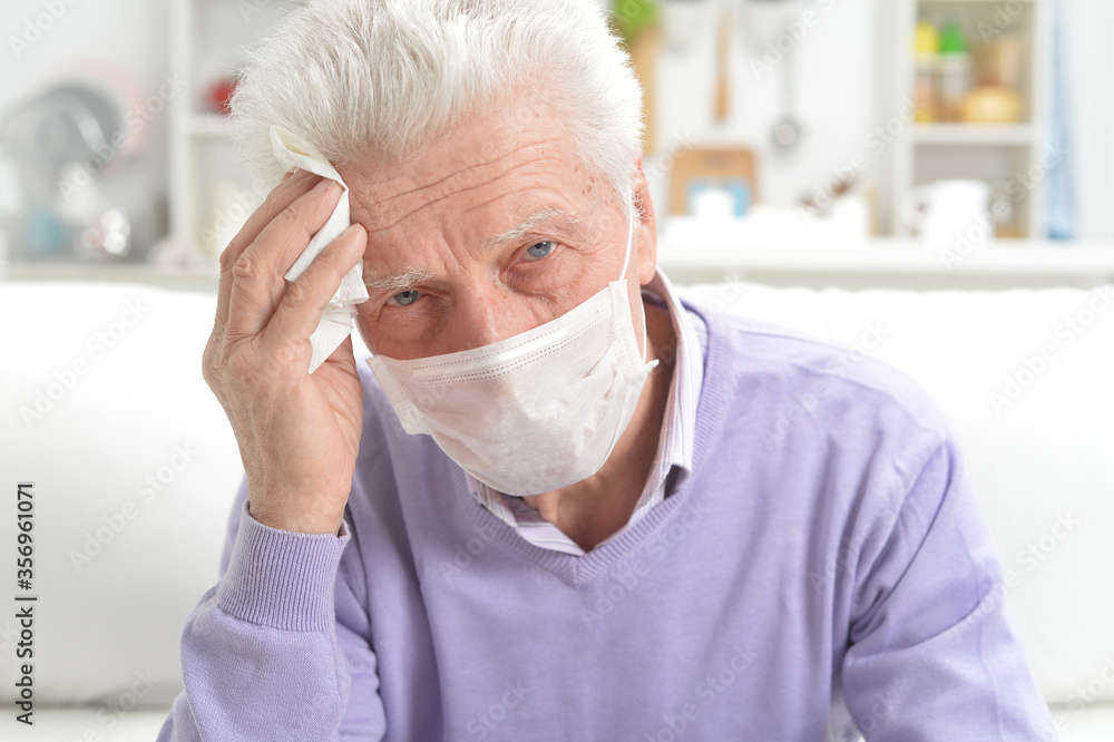 Sad sick senior man with facial mask