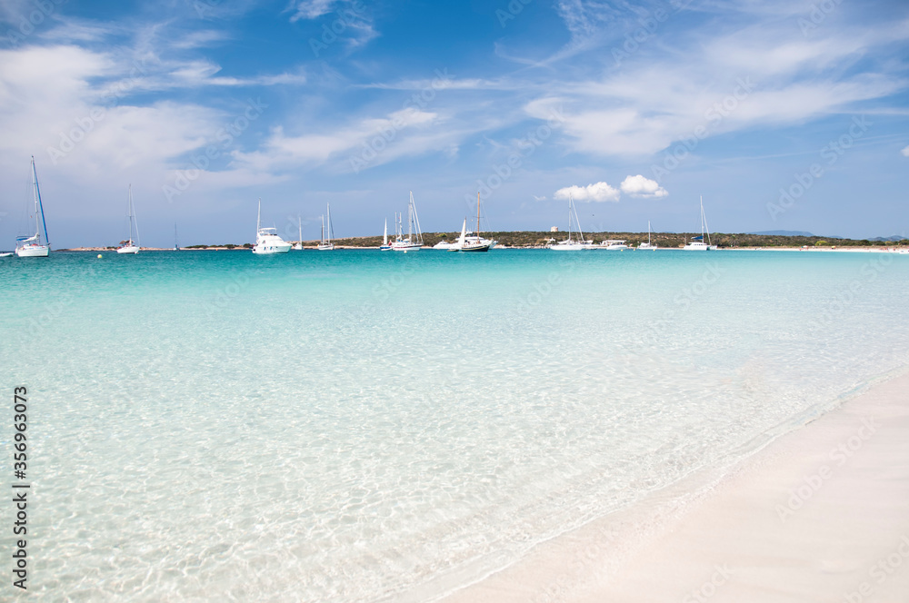 Fantastic deserted beach with transparent water and white sand, in the background the quiet bay, an ideal place to anchor the boat. Formentera, Balearic Islands, Spain