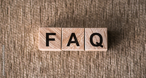 concept of FAQ word on wooden cubes on table. Closeup