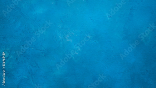 A blue cent wall textured background with small cracks. 