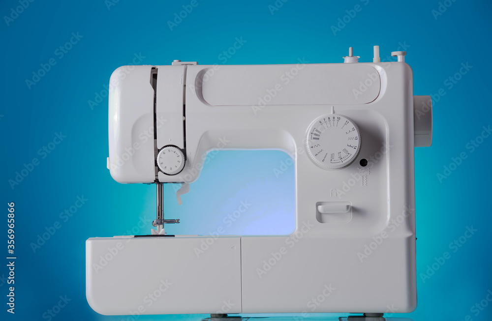 Modern sewing machine close-up on blue background
