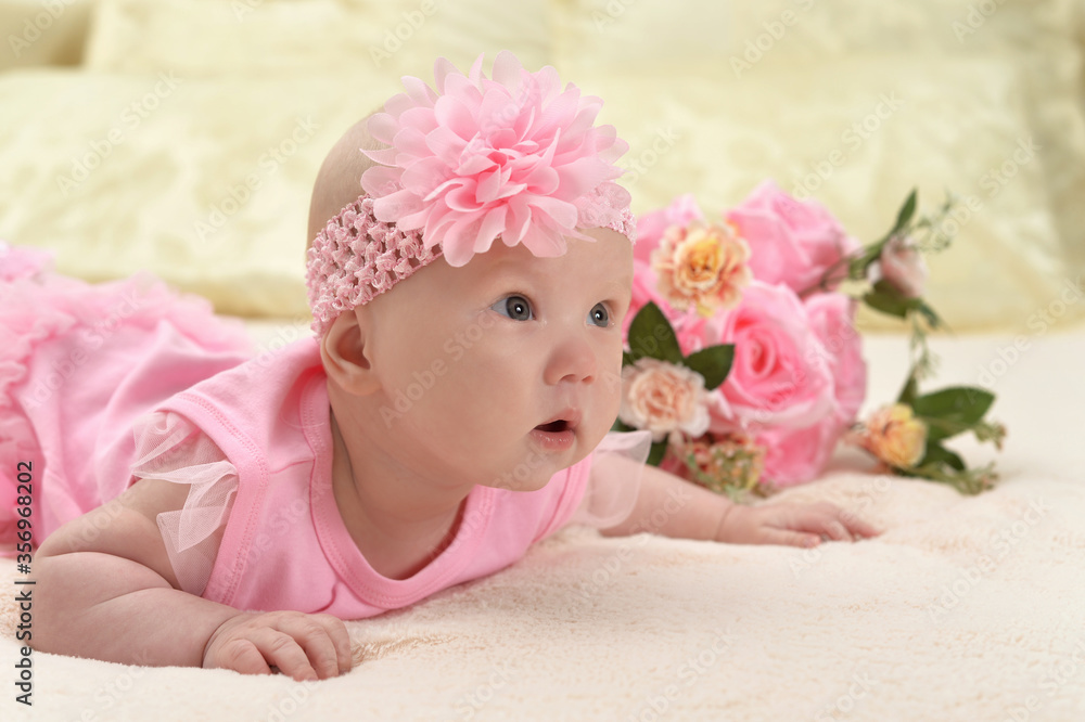 Cute little baby girl on bed with flowers Cute little baby girl on bed with flowers