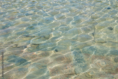 Waves and glare on the surface of the water. Shallow. Fountain. Background