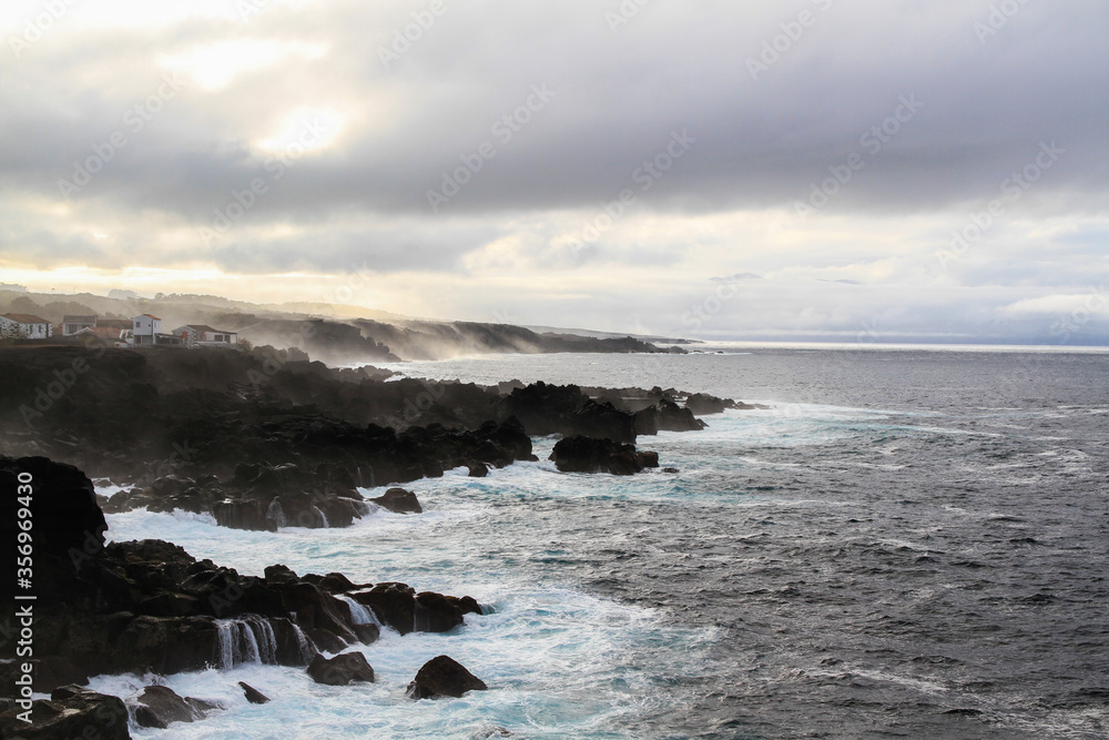 Wild seascape at Pico, Azores, Portugal, with black lava rocks on the coast Wild seascape at Pico, Azores, Portugal, with black lava rocks on the coast
