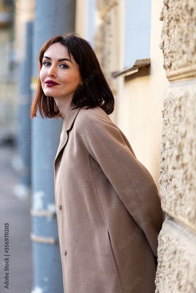 Fototapeta premium Woman in black pantsuit walks on promenade