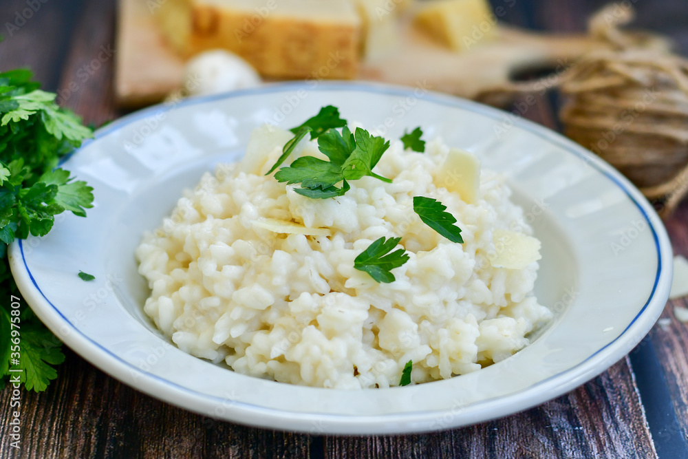 Italian creamy cheese risotto with parmesan cheese and fresh basil on rustic background Italian creamy cheese risotto with parmesan cheese and fresh basil on rustic background