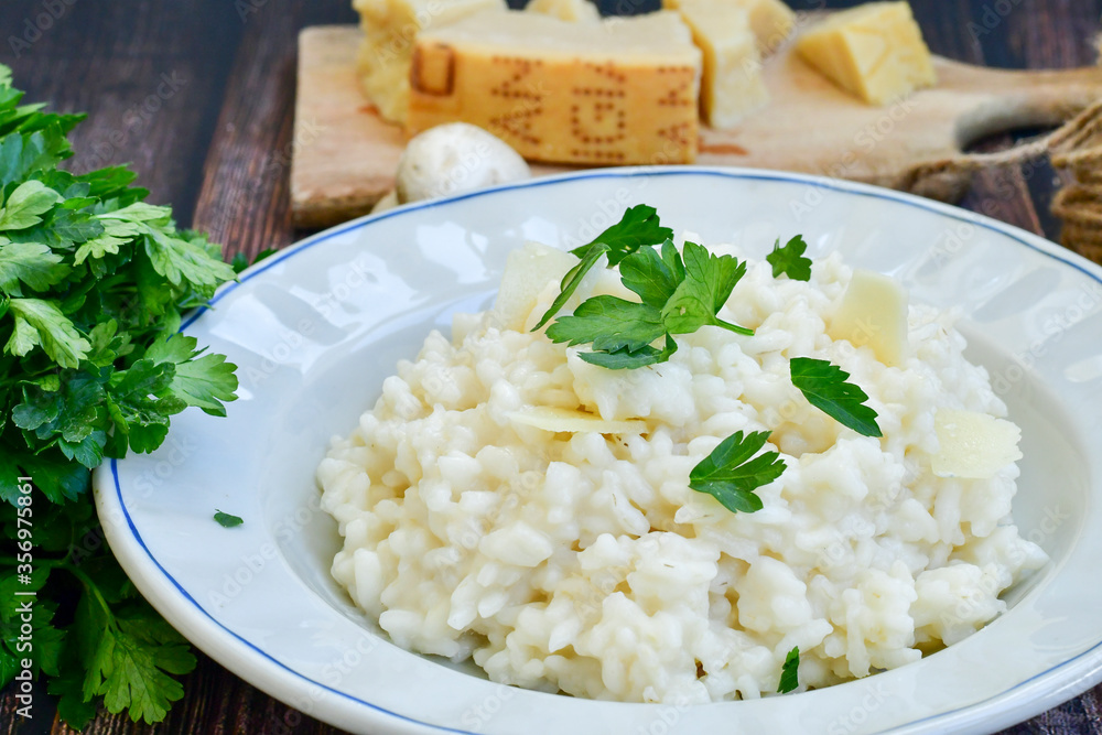 Italian creamy cheese risotto with parmesan cheese and fresh basil on rustic background Italian creamy cheese risotto with parmesan cheese and fresh basil on rustic background
