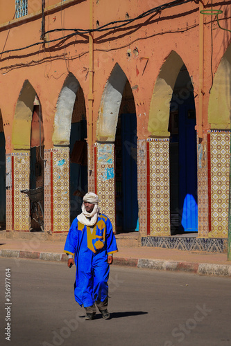 Arabischer Mann mit Turban und blauer Djellaba überquert in Marokko eine Strasse