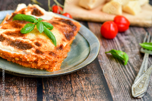  Delicious Home made Lasagna bolognese with minced meat,tomato sauce and spinach on a wooden rustic background.Home made italian meal