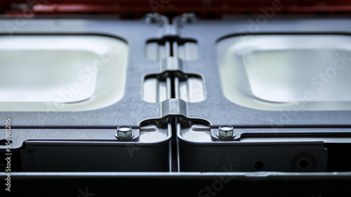 Abstract and symmetrical image of lithium-ion cells bonded together by a metal plate.