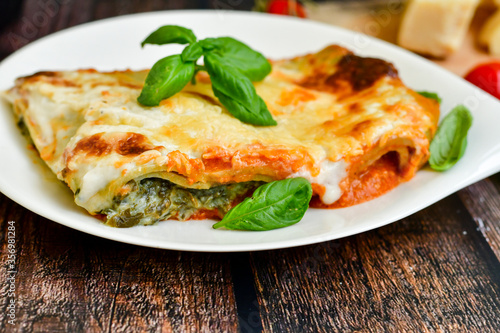   Delicious Home made Lasagna  with minced meat,tomato sauce and spinach  on a wooden rustic  background.Home made italian meal