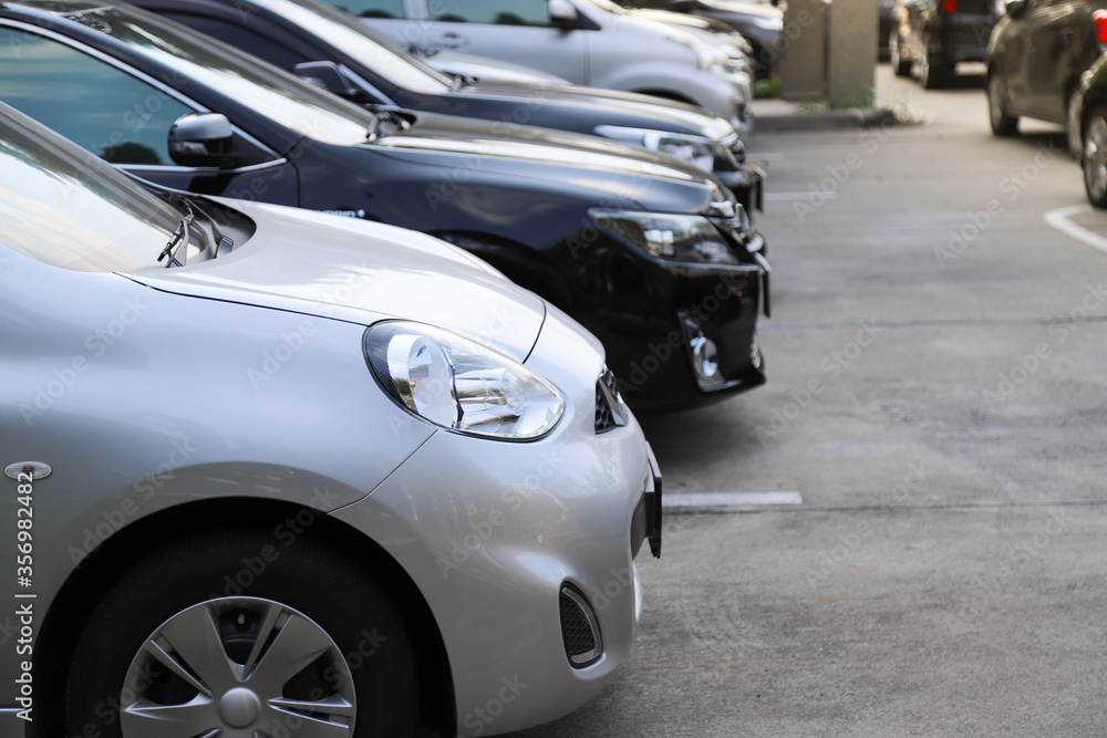 Closeup of front side of bronze car with  other cars parking in outdoor parking area,