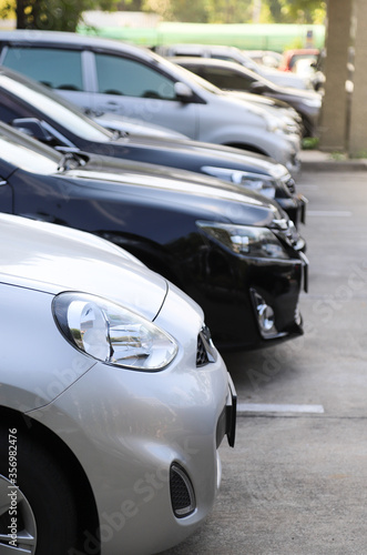 Closeup of front side of bronze car with  other cars parking in outdoor parking area.  Vertical view. © Amphon