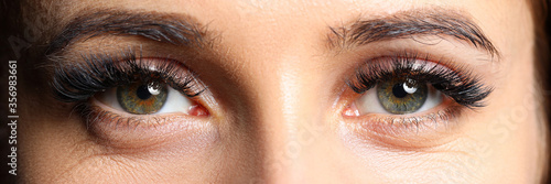 Obraz na płótnie Pair of beautiful female green colored eyes with eyelashes extensions