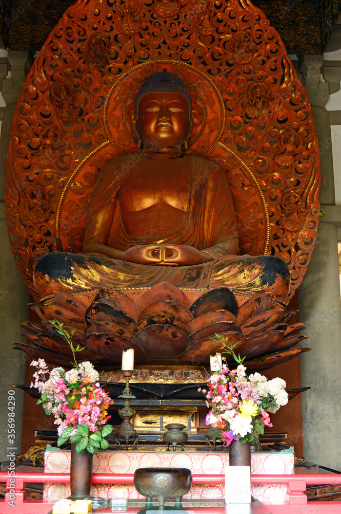 Fototapeta premium A statue of Buddha sits in the Byodo-in temple at the Valley of the Temples in Hawaii