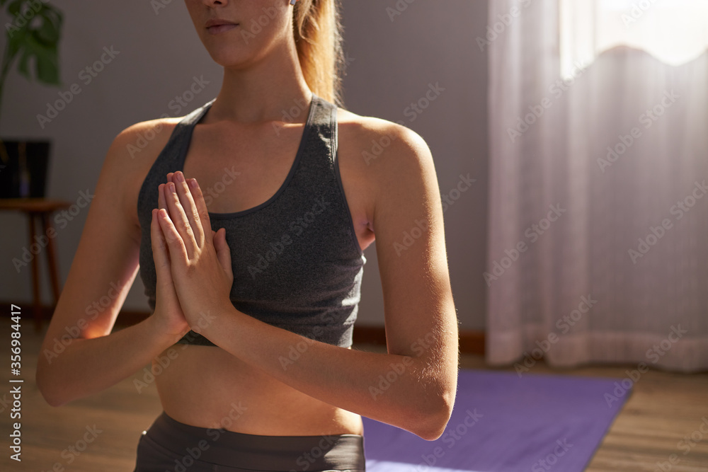 Fototapeta premium Young female meditating on yoga mat