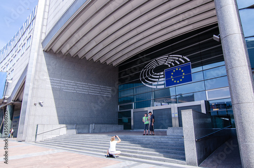 Brussels, Belgium, August 2019. External view of the modern metal and glass palaces which house the European Parliament. Entrance dedicated to Altiero Spinelli: tourists take souvenir photos. photo