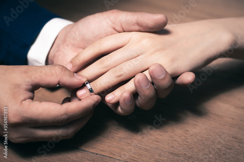 Groom wearing the wedding ring to Bride finger.