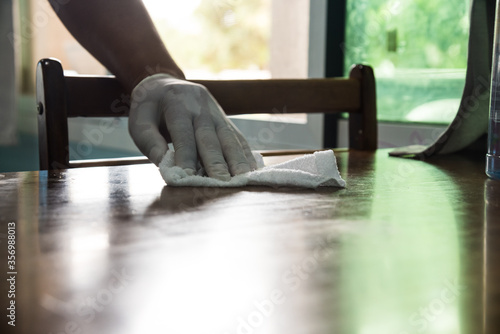 Man cleaning a table with a rag