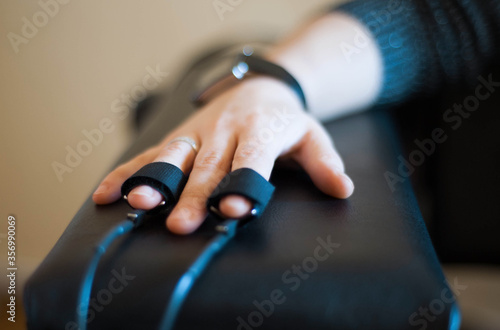 Tableau sur toile woman's hand in a lie detector apparatus close-up