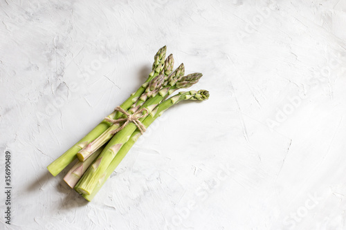 bunch of green fresh asparagus on a light background, top view