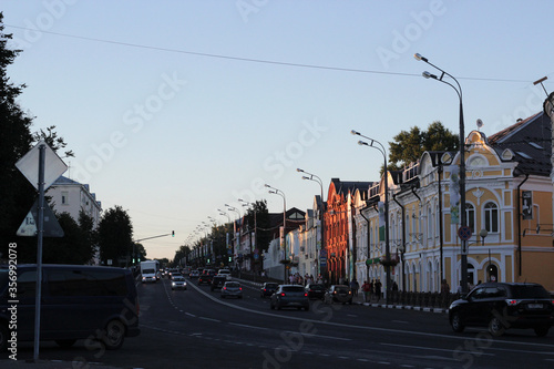 Street in the city. There are cars on the road and houses on either side of it. Roads in Russia. © Ксения Ульянова
