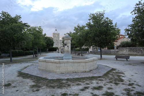 Fountain in a public place with a medieval tower in background