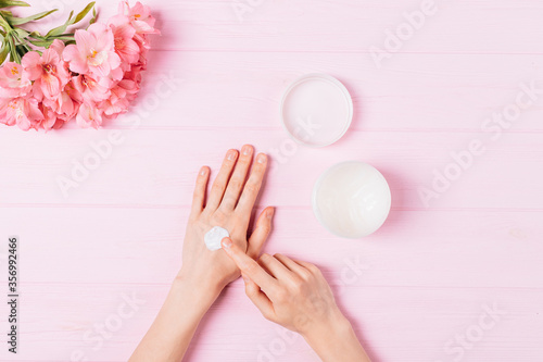 Female hands apply cosmetic moisturizer balm