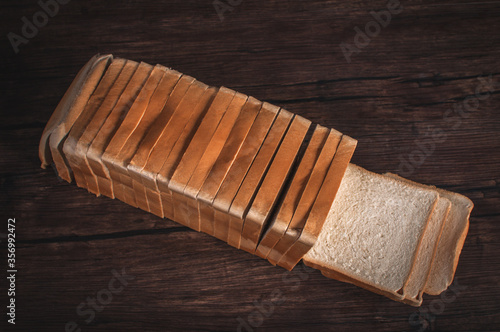 pan rebanado sobre fondo de madera oscuro