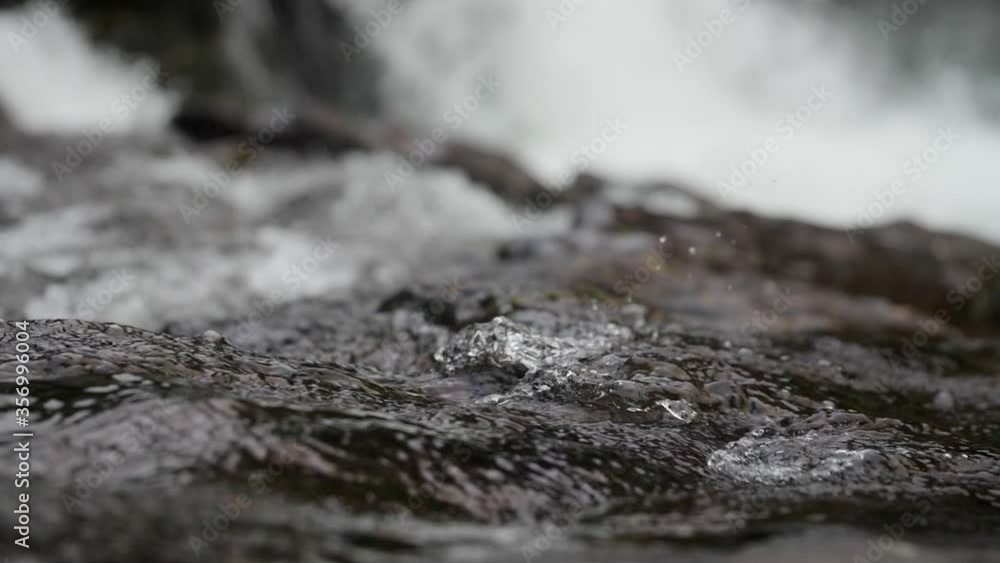A slow motion macro shot of water flowing with Lucia falls looming in the background in Vancouver, Washington. A slow motion macro shot of water flowing with Lucia falls looming in the background in Vancouver, Washington.