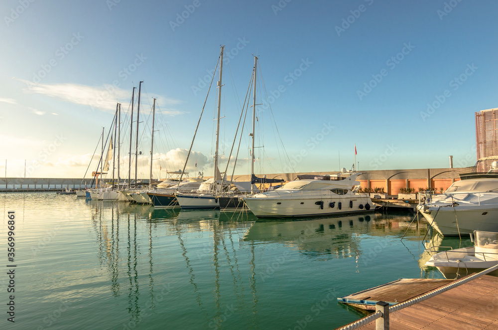 Marina with walkway and boats at sunset