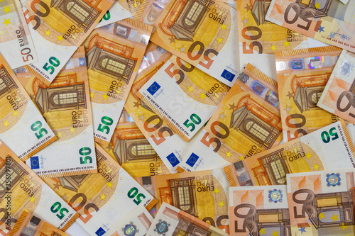 Banknotes of 50 fifty euros are scattered in a chaotic manner. European currency blank for design, background. View from above.