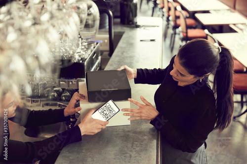 Owner and coworker with modem box at checkout counter in cafe photo