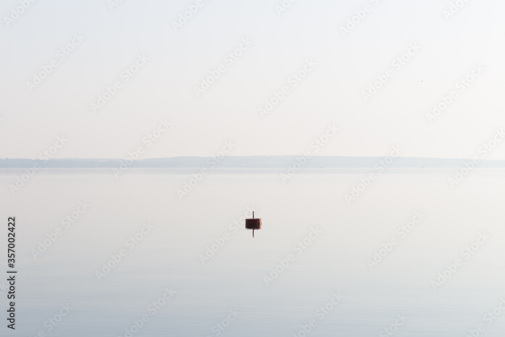 Lonely buoy on a lake in the morning light