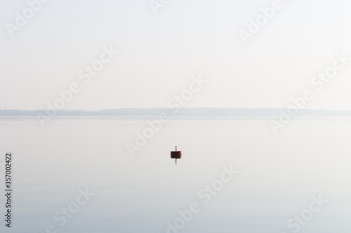 Lonely buoy on a lake in the morning light
