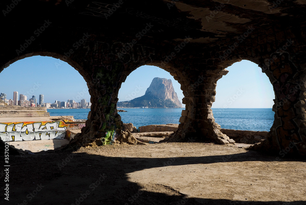 La ciudad de Calpe vista desde tres agujeros de piedra en un acantilado del mar