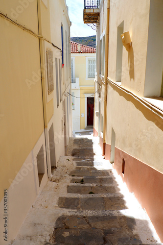 One of the charms of the Greek Cycladic Islands, in the heart of the Aegean Sea are the narrow streets: white houses, small flowered balconies and cobbled stairs