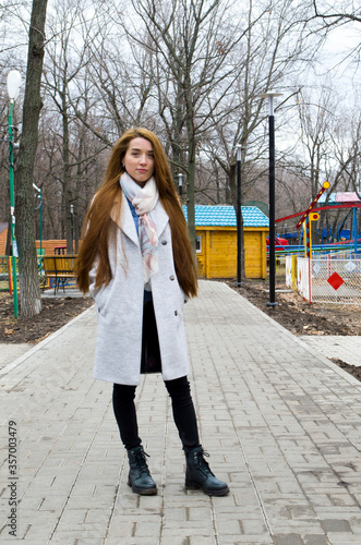 The girl is walking in the park. Read a book.